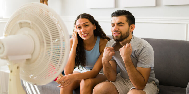 Couple sitting in front of fan